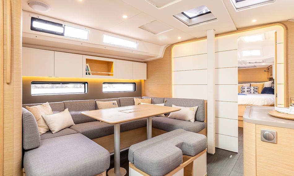 Luxe interieur van de Dufour 41 met ruime salon, zithoek en doorkijk naar de cabine, gebruikt voor zakelijke zeilarrangementen van PWRD Yacht.